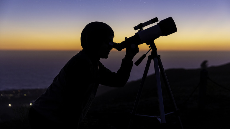 Boy stargazing through telescope