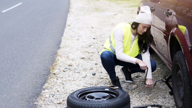 A woman fixing a flat tire