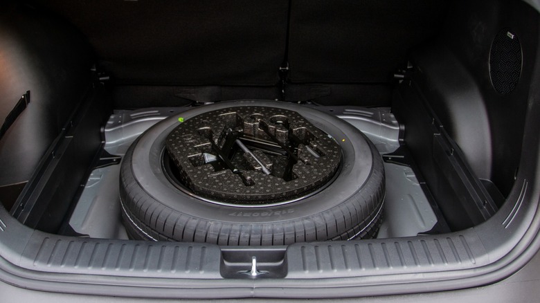 A spare tire in the trunk of a car