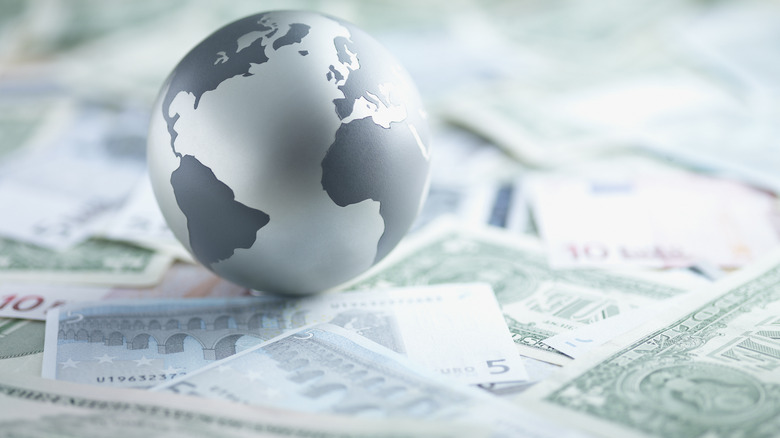 A globe sitting on top of currencies