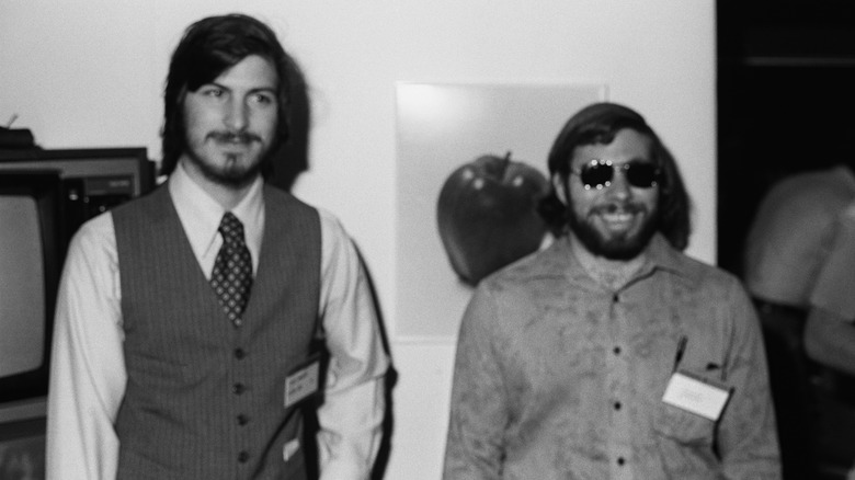 Steve Jobs and Steve Wozniak in front of an Apple logo