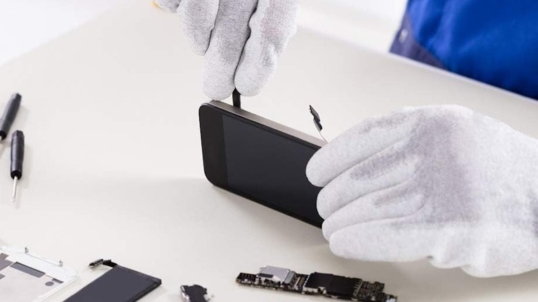 Person using a spudger to open up a smartphone for repair.