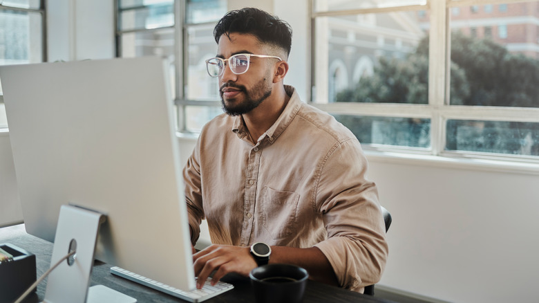 man writing on mac device