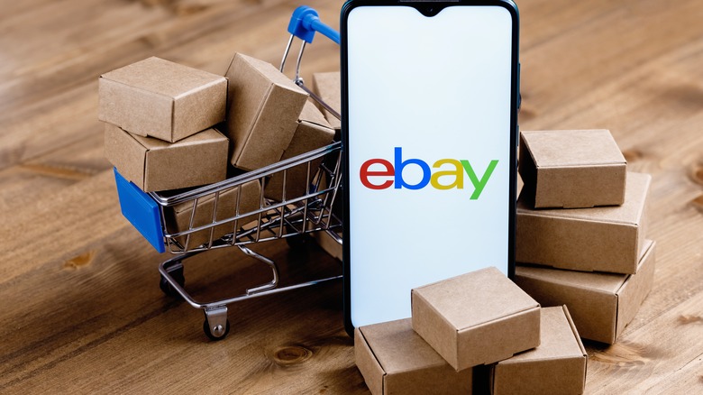 eBay logo with boxes and cart