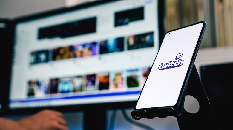 Twitch logo with person browsing Twitch website