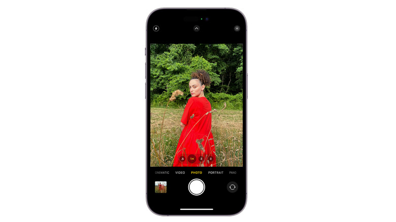 woman in red dress in a field viewed through iPhone camera