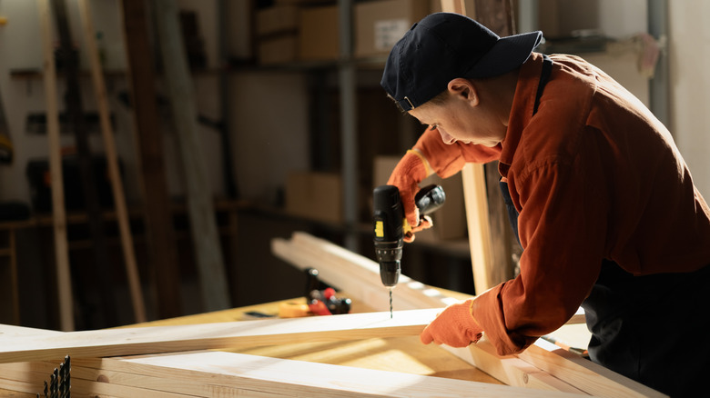 Woman drilling into a wooden board