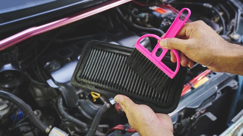 Person cleaning dirty air filter