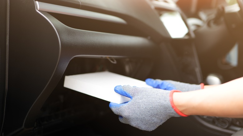 Person replacing cabin air filter