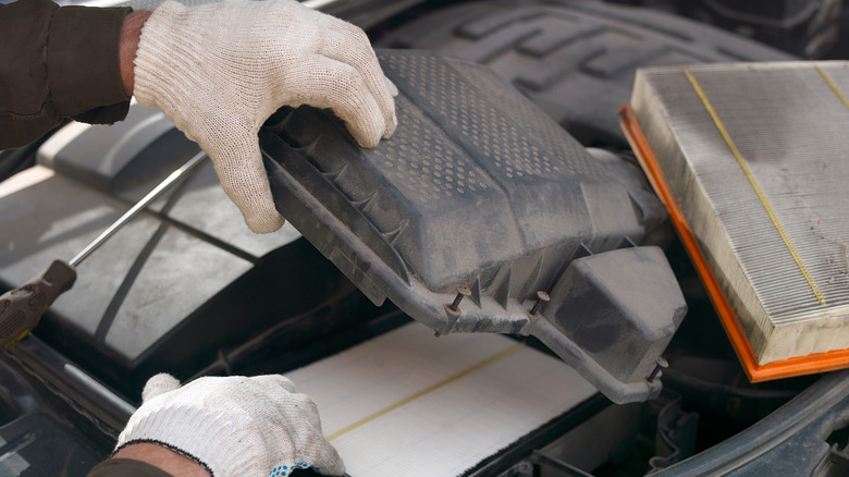 Person reaching for air filter