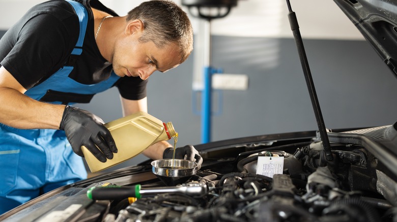 Mechanic pouring motor oil