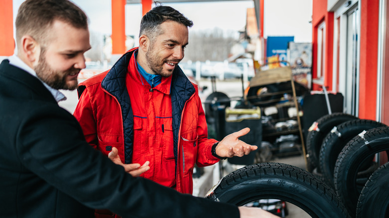 Men looking at car tires