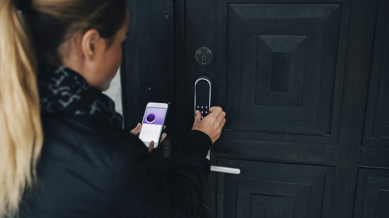 Woman inputting security code into smart doorbell