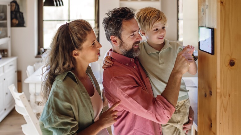 Family looking at smart thermostat