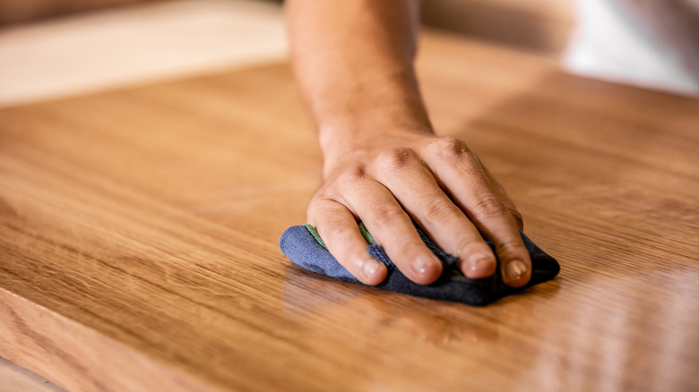 Person rubbing oil into wood