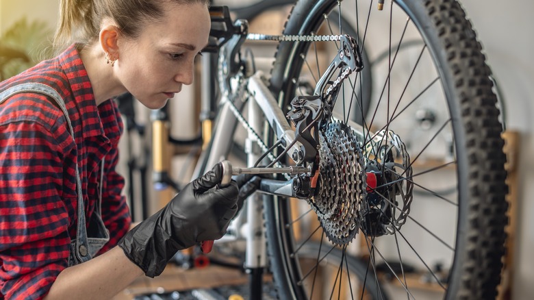 Woman maintaining bicycle