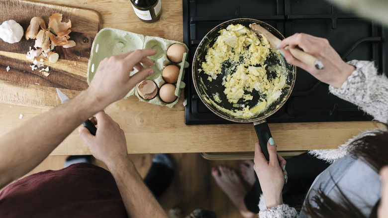 Couple preparing scrambled eggs