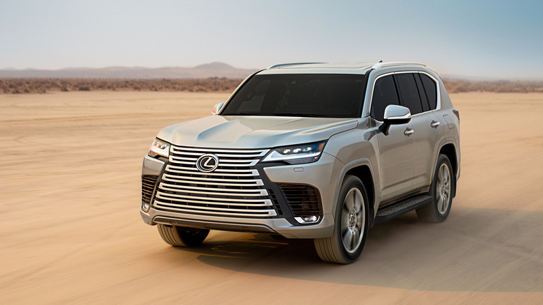 The Lexus LX driving across the desert, front 3/4 view