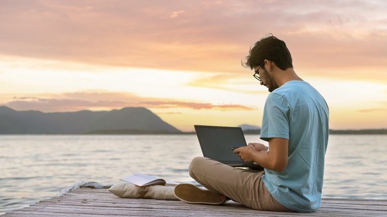 man laptop by river