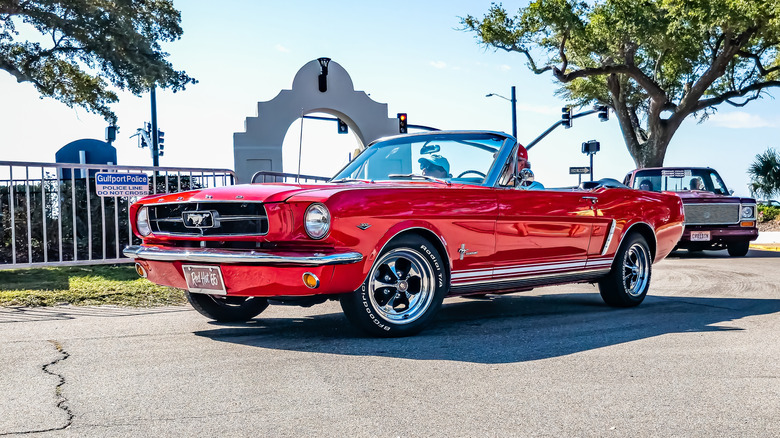 Red ford mustang convertible leaving parking lot