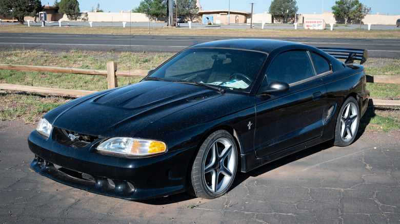 Black fourth generation Mustang in parking lot