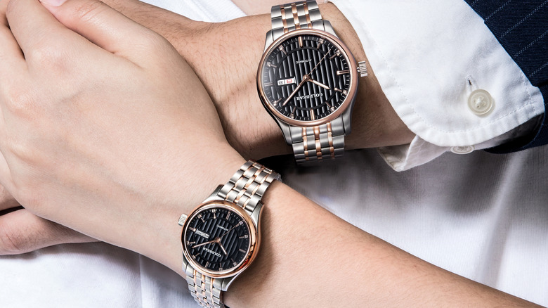 A couple wearing matching wristwatches