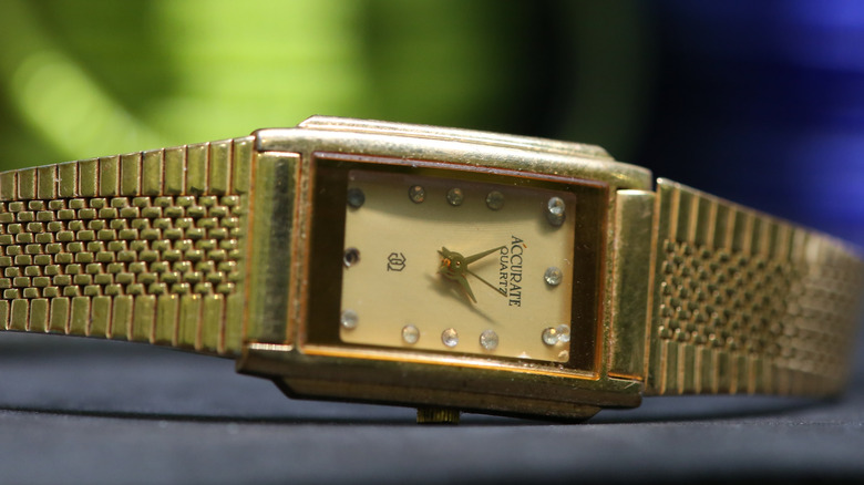 Quartz gold-plated watch laying on a display case