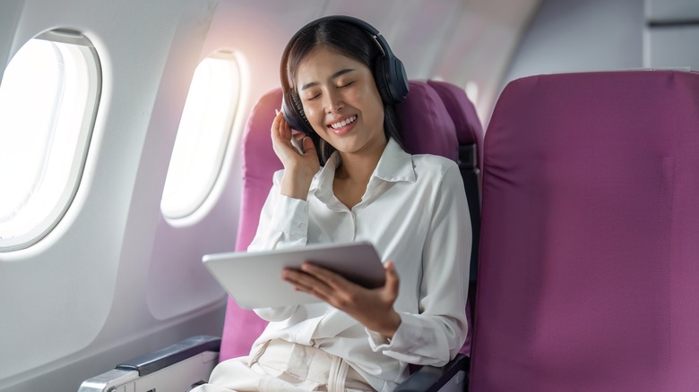 woman listening to headphones airplane