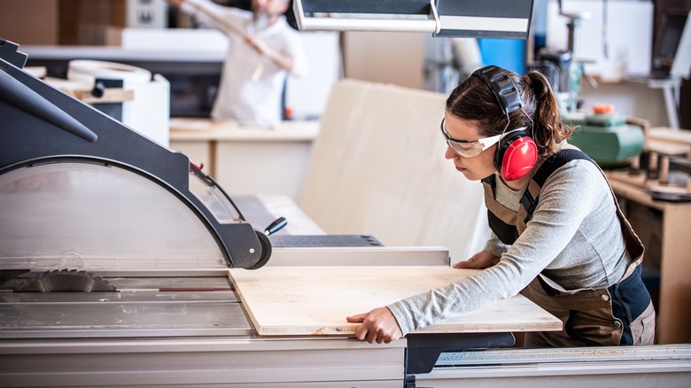 woman cutting wood with hearing protection