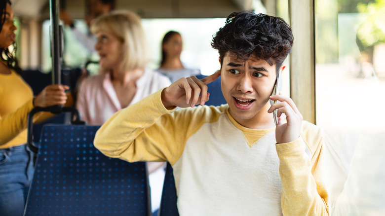 boy making phonecall on noisy bus