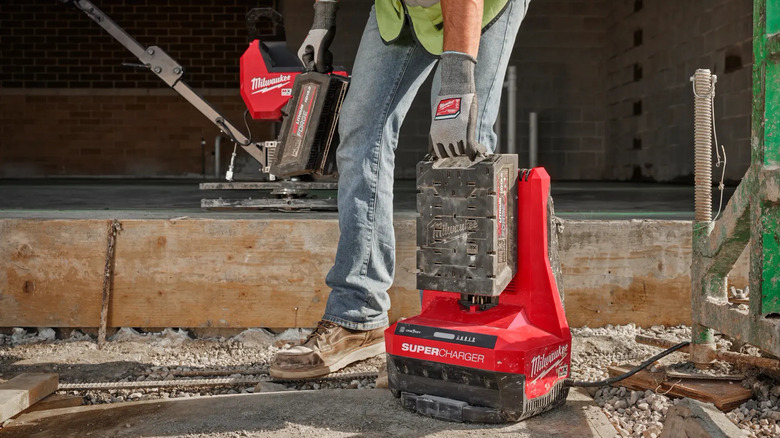 Worker carrying Milwaukee battery pack and charger