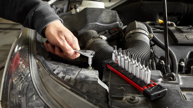 Mechanic using Milwaukee tools on car