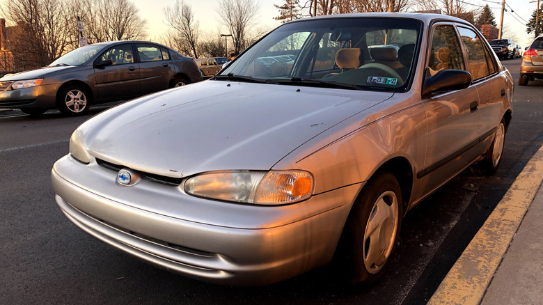 Silver 2001 Chevrolet Prizm parked by sidewalk