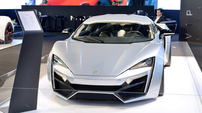 A silver Lykan Hypersport at an auto show, front view