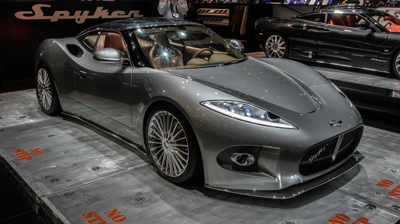 The Spyker B6 Venator in silver at an auto show, front 3/4 view