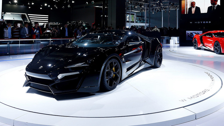 The Lykan Hypersport at an auto show in black, front 3/4 view