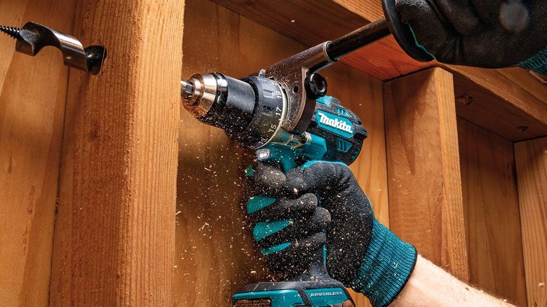 Makita hammer driver-drill making hole in wood framing