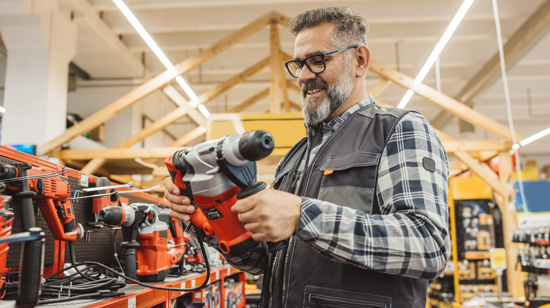 Man in plaid shirt shopping for tools in a retail store