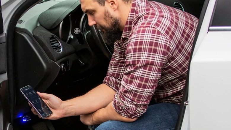 man using BlueDriver app in vehicle