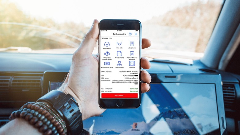 Car Scanner app on phone held in hand inside car