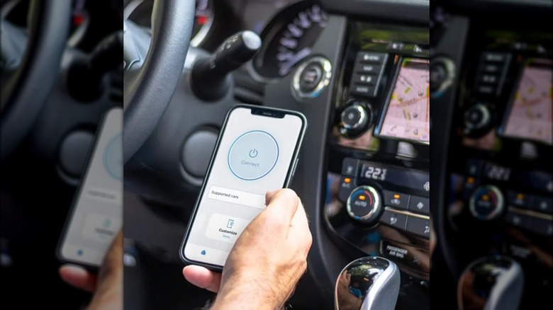 Carista app on smartphone in hand inside car