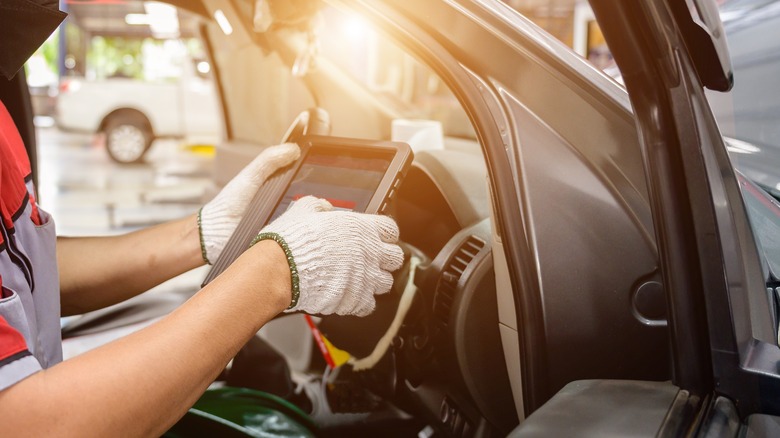 auto technician checking OBD on vehicle