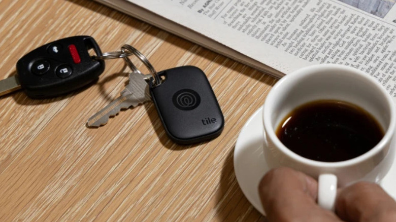 Tile attached to a ring of keys, with a cup of coffee next to them