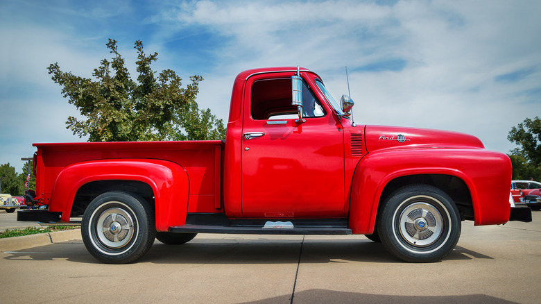 Side view of a red 1955 Ford F-100 pickup