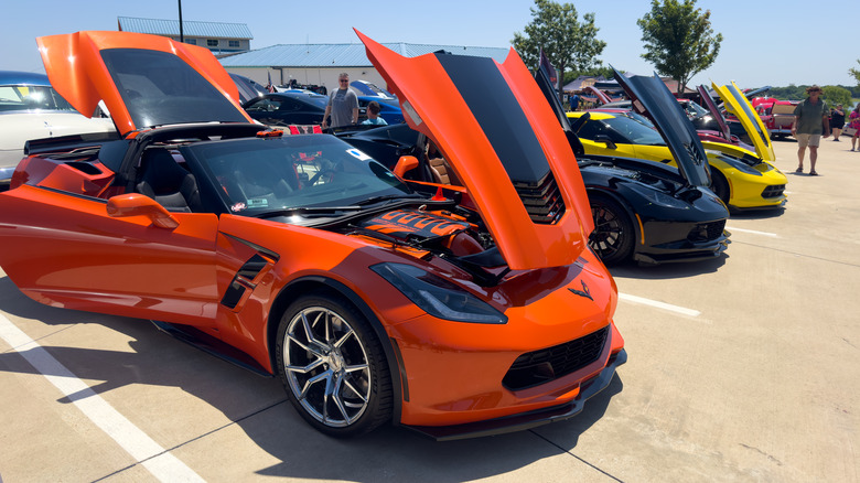 An orange Corvette with the hood popped