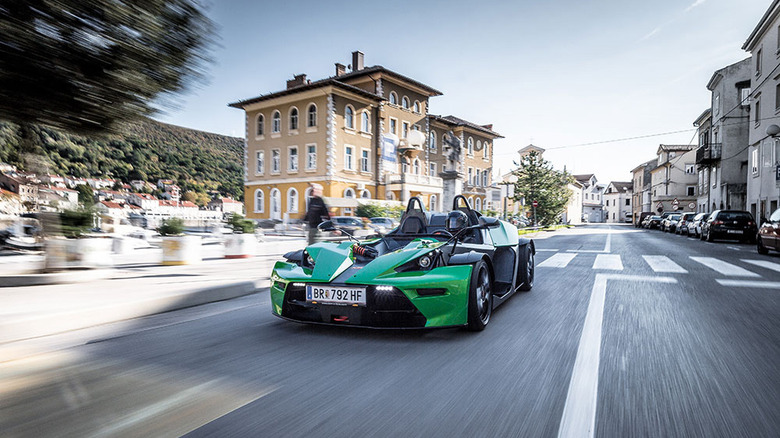 Green KTM X-Bow R driving on urban roads