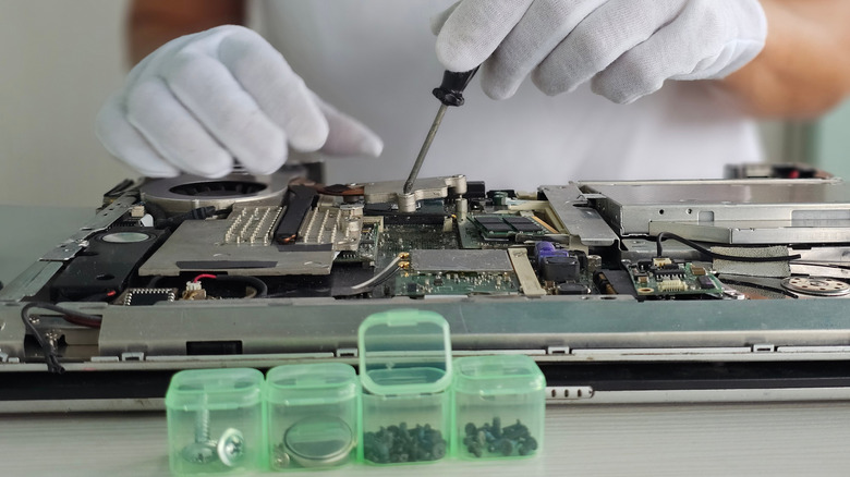 A person working on the internal components of a laptop