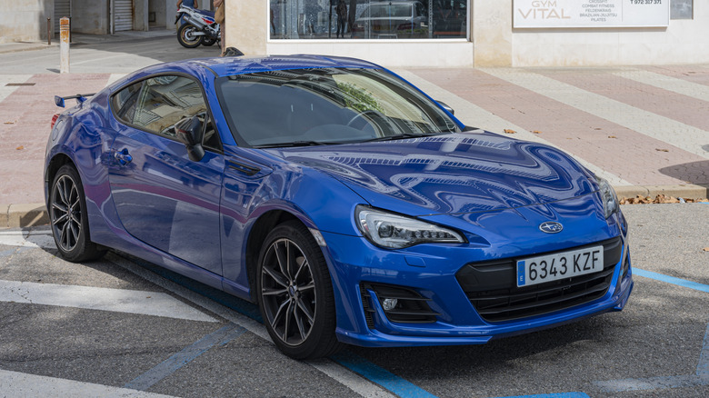 A first generation facelift Subaru BRZ in blue, street parked, front 3/4 view