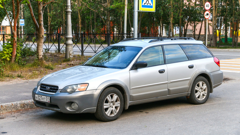 A two-tone silver and gray Subaru Outback, street-parked, front 3/4 view