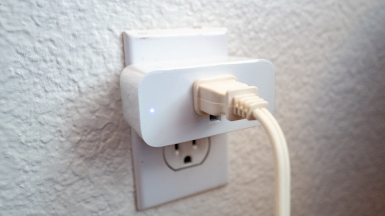 A cable inserted into a smart plug that's connected to a wall socket